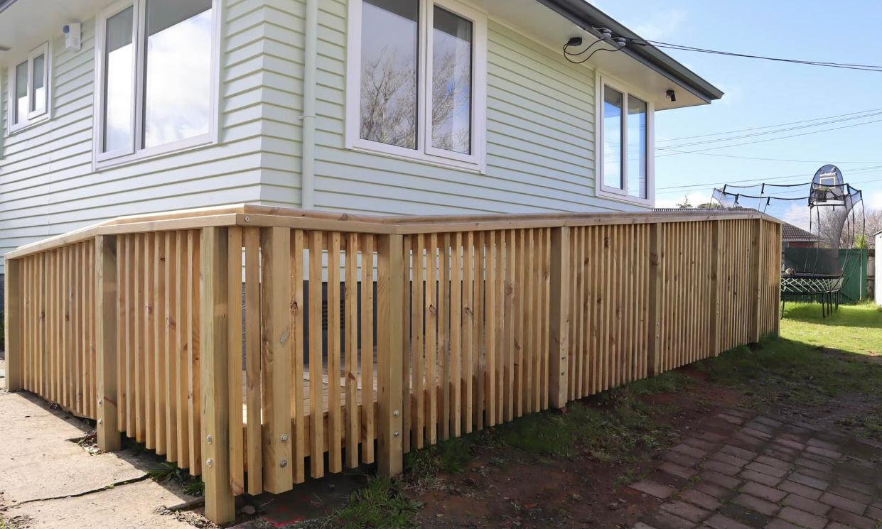 Vertical timber batten fence beside a weatherboard house
