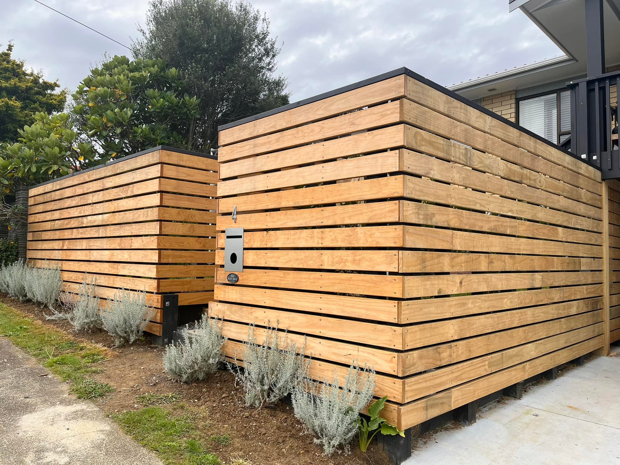 Horizontal timber slat fence with low planting along the base
